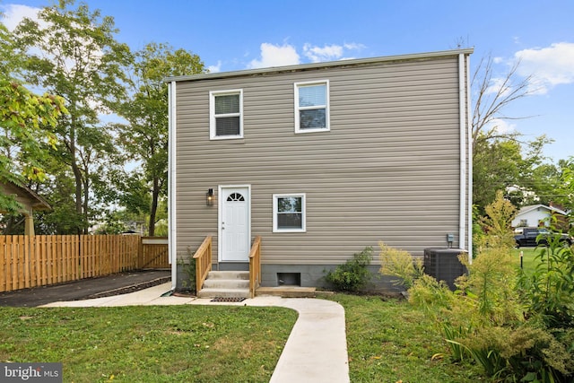 view of front of house featuring a front lawn and central AC unit