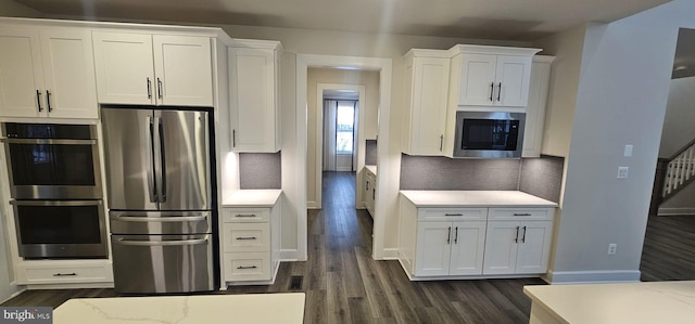 kitchen with stainless steel appliances, dark hardwood / wood-style floors, and white cabinets