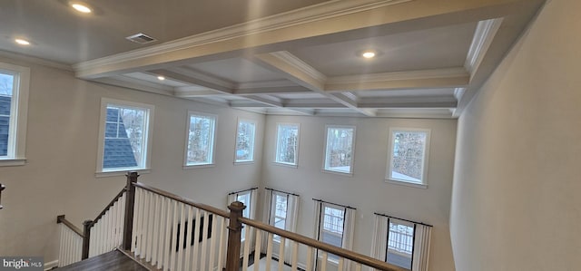 interior space featuring coffered ceiling, a towering ceiling, ornamental molding, and beamed ceiling