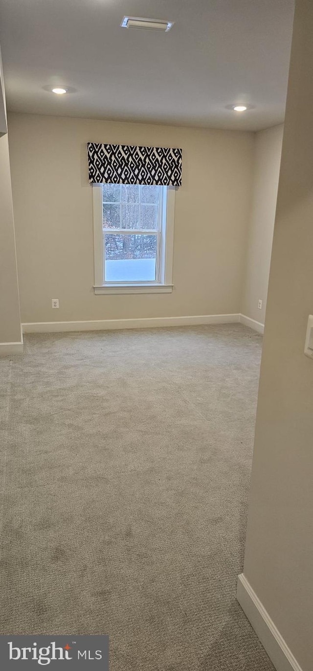 unfurnished room featuring light colored carpet