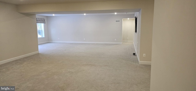 spare room featuring light carpet