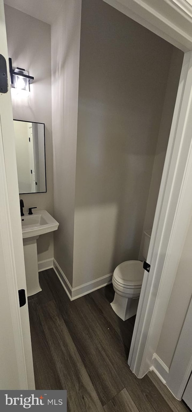 bathroom with hardwood / wood-style flooring and toilet