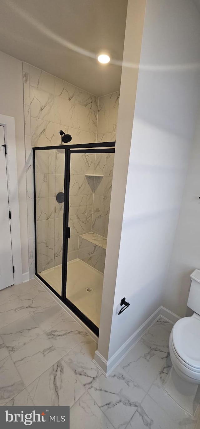 bathroom featuring walk in shower and toilet