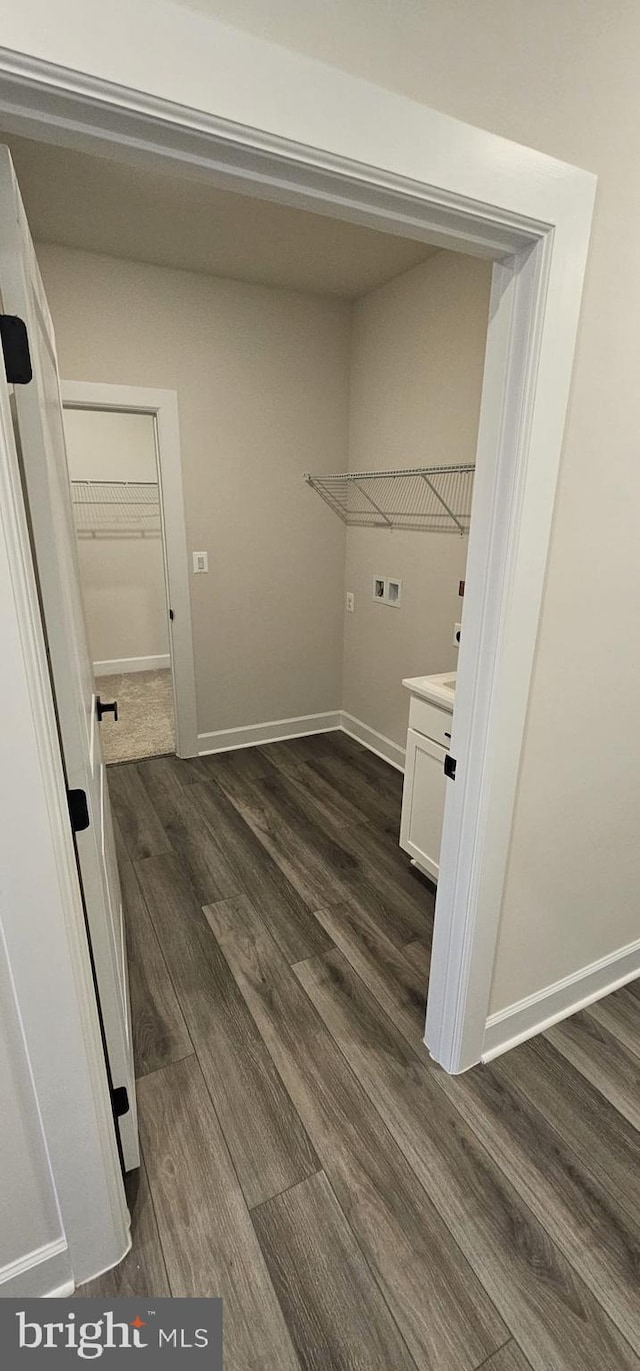 clothes washing area featuring dark hardwood / wood-style floors and washer hookup