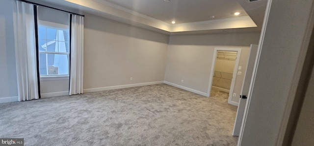 unfurnished room featuring a tray ceiling, crown molding, and light colored carpet