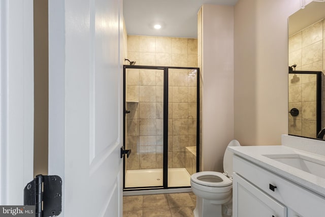 bathroom featuring vanity, toilet, tile patterned flooring, and a shower with door