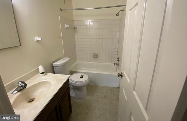 full bathroom with tiled shower / bath, tile patterned flooring, vanity, and toilet