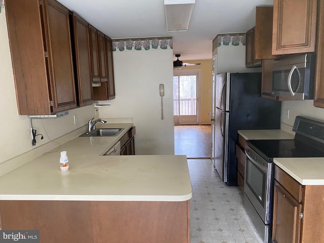 kitchen featuring kitchen peninsula, ceiling fan, sink, and stainless steel appliances