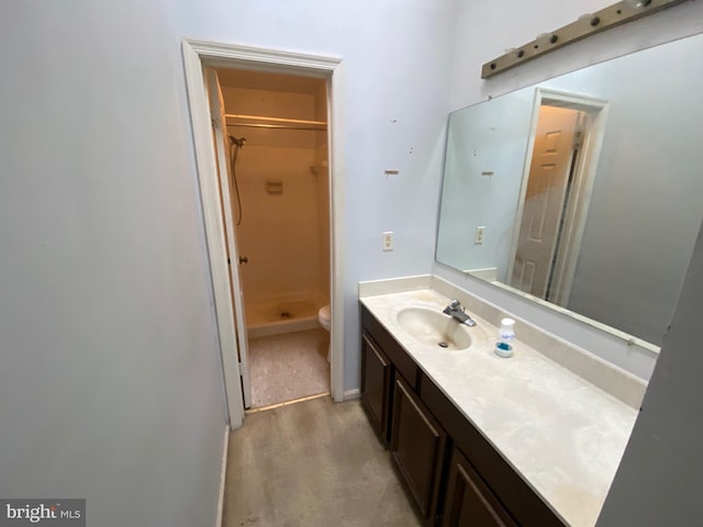 bathroom with vanity, toilet, and walk in shower