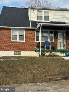 view of front of house with a front yard and covered porch