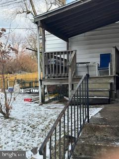 snow covered deck featuring a carport