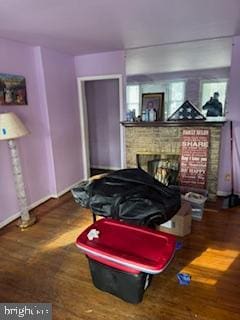 interior space featuring hardwood / wood-style flooring and a brick fireplace