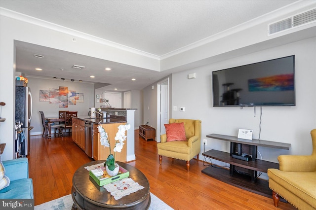 living room with light hardwood / wood-style floors, sink, and a textured ceiling