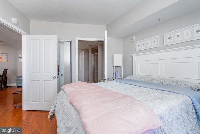 bedroom featuring wood-type flooring and a textured ceiling