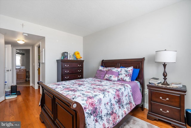 bedroom with wood-type flooring and a textured ceiling