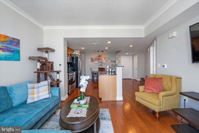 living room featuring hardwood / wood-style flooring, ornamental molding, and a textured ceiling