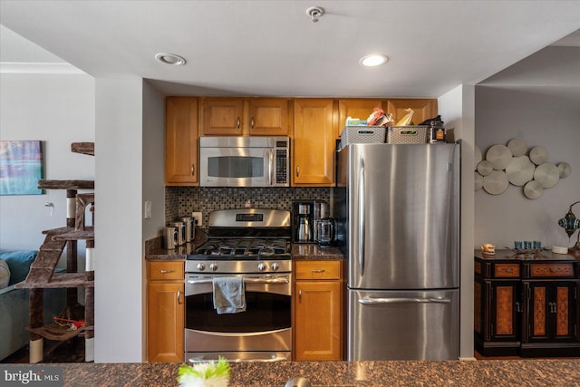 kitchen with tasteful backsplash, dark stone countertops, and appliances with stainless steel finishes