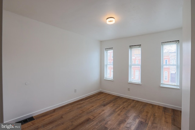 empty room with dark hardwood / wood-style flooring