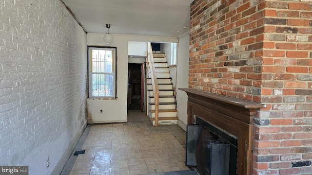 unfurnished living room with brick wall