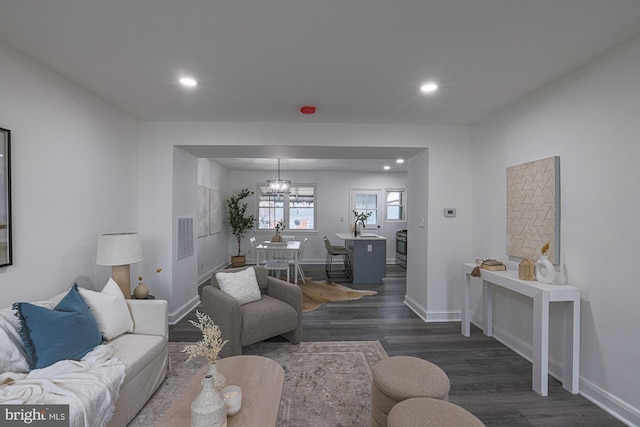 living area with an inviting chandelier, dark wood-type flooring, recessed lighting, and baseboards