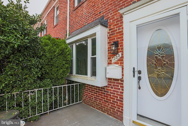 entrance to property featuring brick siding