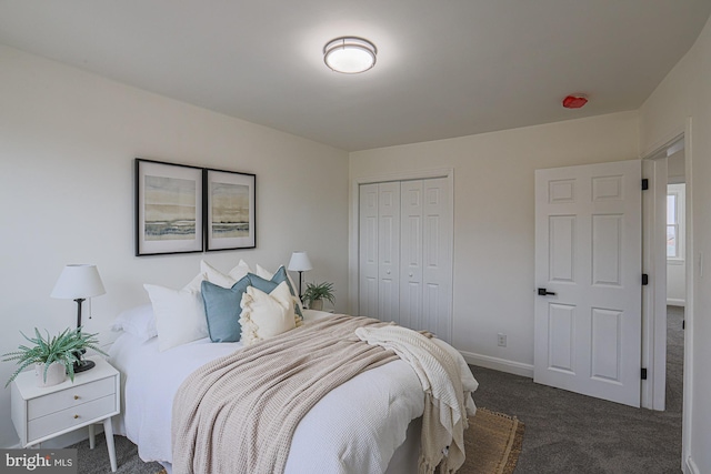 carpeted bedroom featuring a closet and baseboards