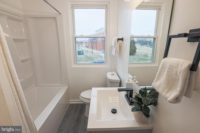 full bathroom with baseboards, toilet, shower / bath combo, wood finished floors, and vanity