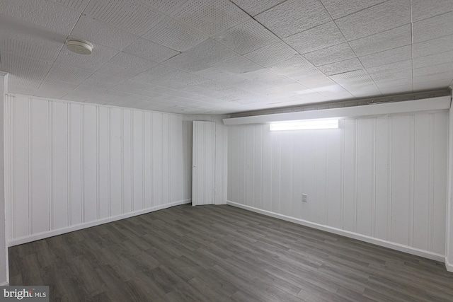 basement with baseboards and wood finished floors