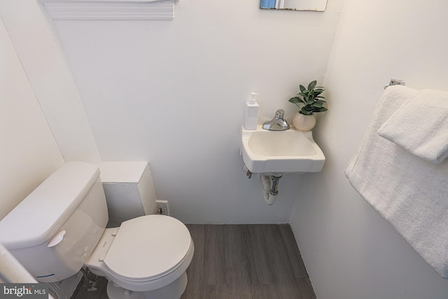 half bath with toilet and wood finished floors