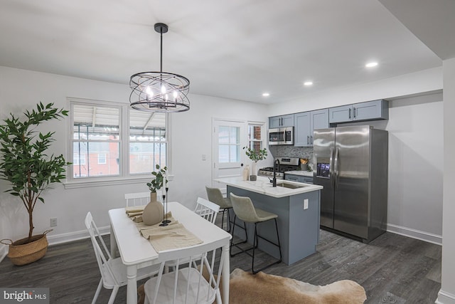 kitchen with backsplash, appliances with stainless steel finishes, light countertops, and dark wood-style flooring