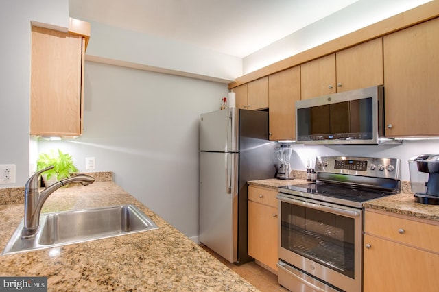 kitchen featuring light brown cabinets, stainless steel appliances, and sink