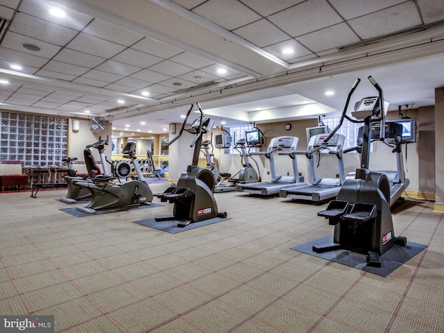 gym featuring a paneled ceiling and light carpet