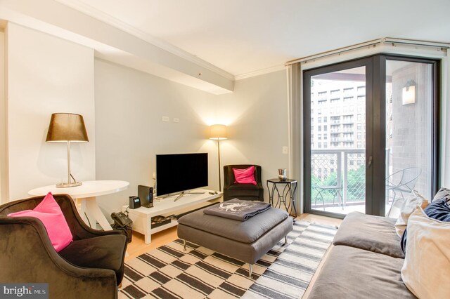 living room featuring hardwood / wood-style flooring, a healthy amount of sunlight, and ornamental molding