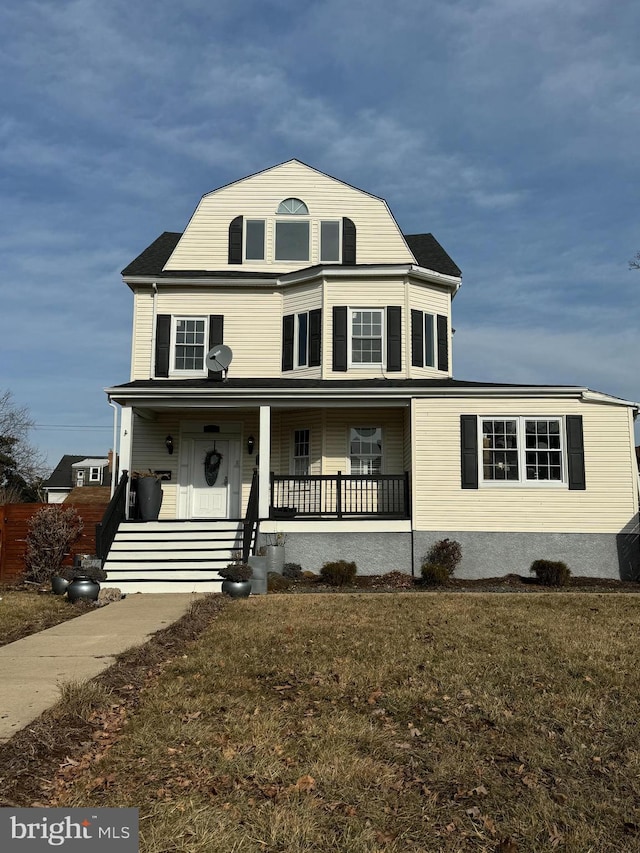 view of front of property featuring covered porch and a front lawn