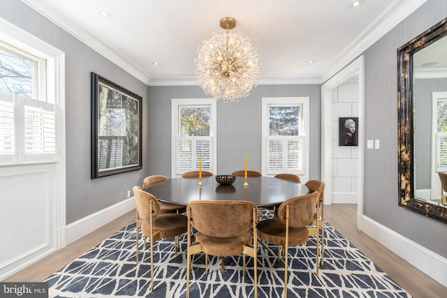 dining space with a chandelier, wood finished floors, baseboards, and ornamental molding