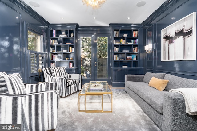 living room with built in shelves and ornamental molding