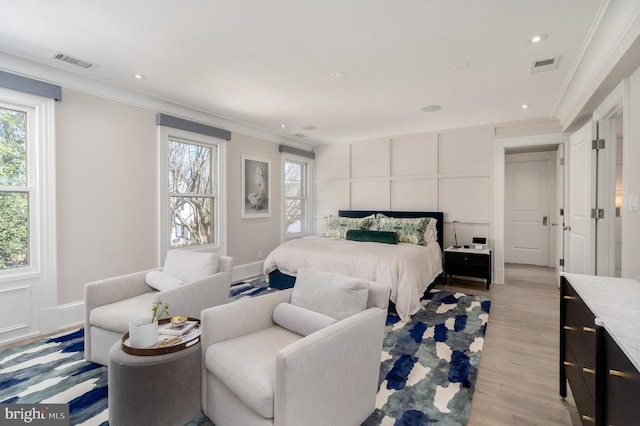 bedroom with visible vents, light wood-style floors, and crown molding