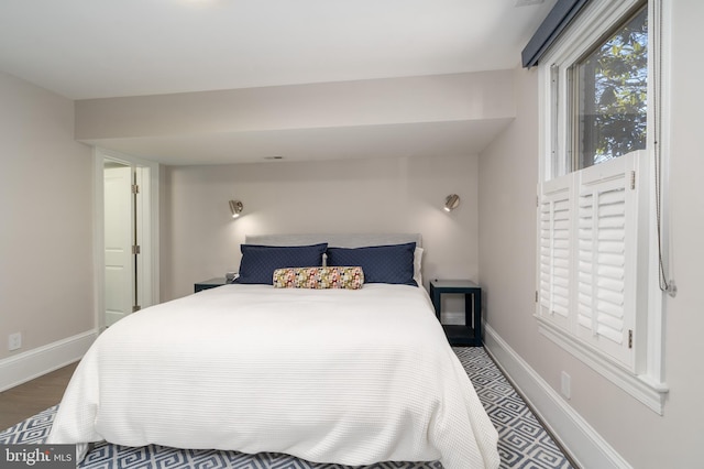 bedroom with wood finished floors and baseboards