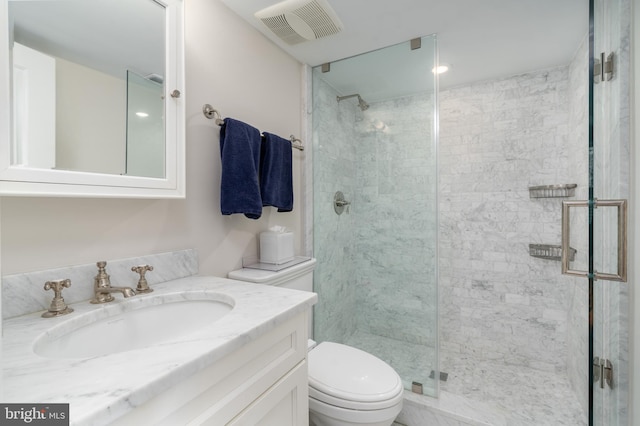 bathroom featuring visible vents, vanity, toilet, and a shower stall