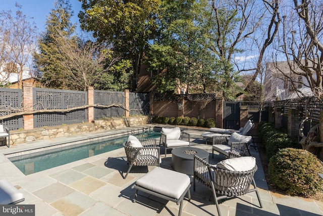 view of patio featuring a fenced backyard, a fenced in pool, and an outdoor fire pit