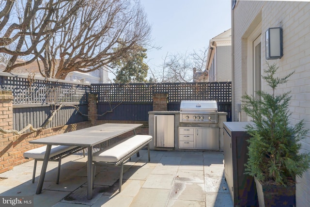 view of patio with an outdoor kitchen, outdoor dining area, and a grill