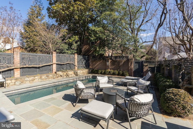 view of pool with a patio area, a fenced backyard, a fenced in pool, and an outdoor fire pit