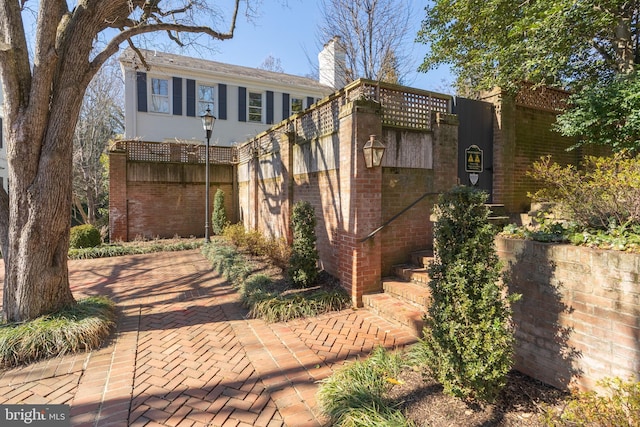 view of front of home with brick siding and a chimney