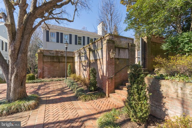 view of front of home featuring brick siding and a chimney