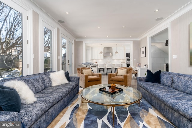 living area with recessed lighting and ornamental molding