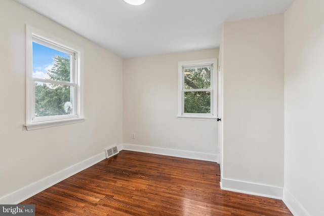 unfurnished room with a wealth of natural light and dark wood-type flooring