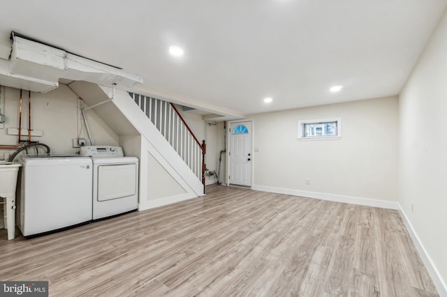 laundry room featuring light hardwood / wood-style flooring and washing machine and clothes dryer