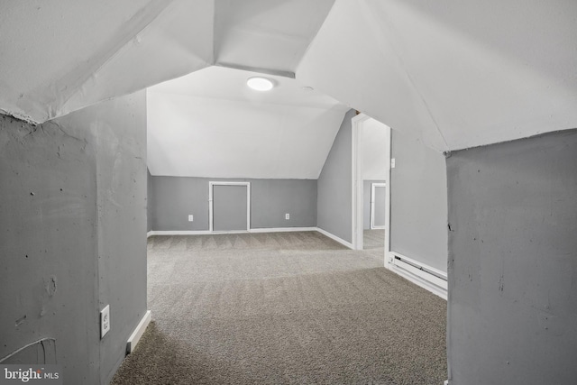 additional living space with carpet, a baseboard radiator, and vaulted ceiling