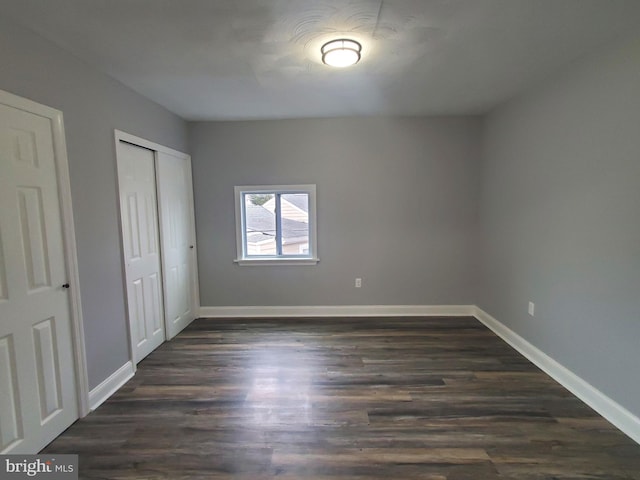 unfurnished bedroom featuring dark hardwood / wood-style floors and a closet