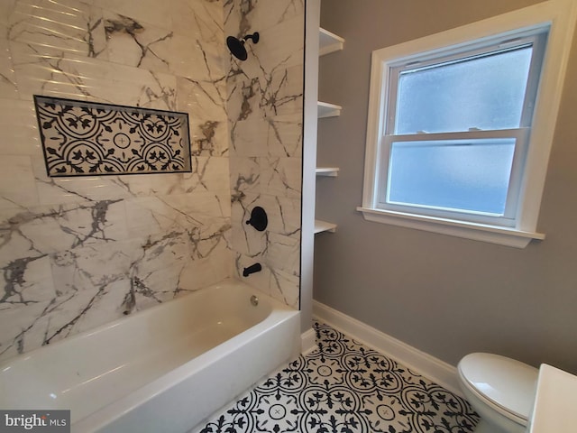 bathroom featuring tiled shower / bath, tile patterned floors, and toilet